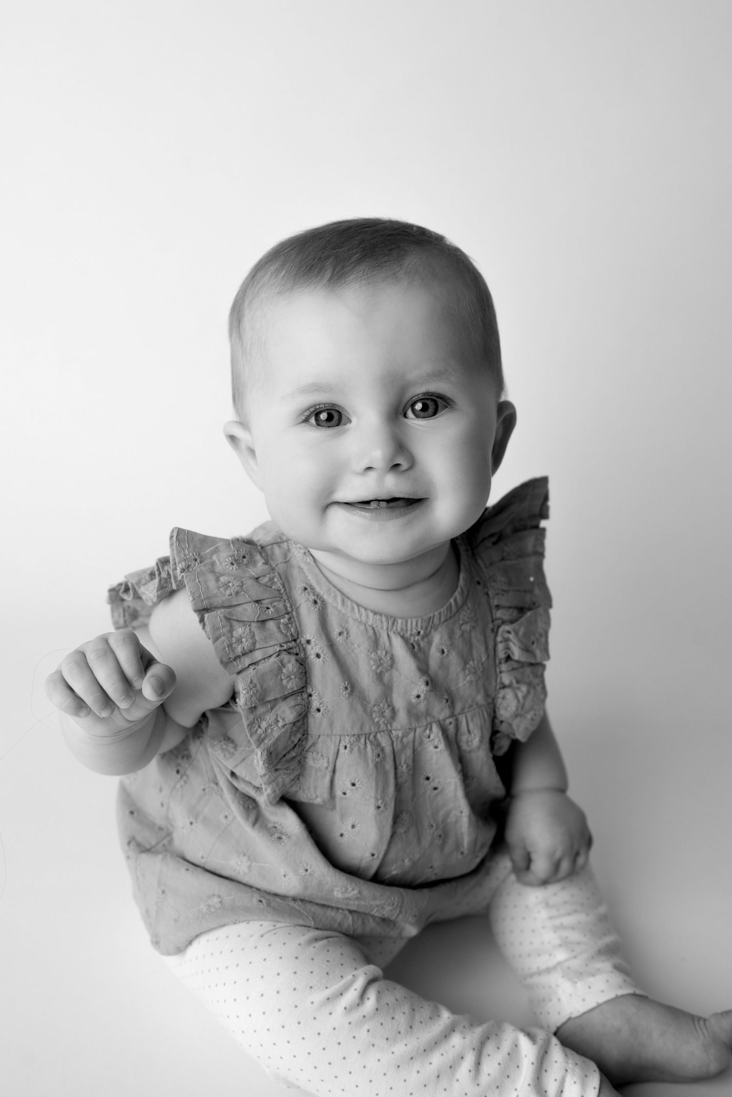 baby girl waving at camera for a family photoshoot